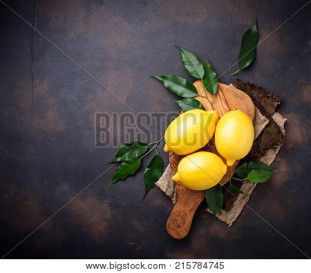 Fresh juicy lemons on rusty background. Selective focus