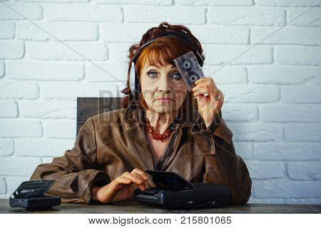 Audio book and new technology education. Old woman with cassette recorder listen music in headphones. Spy and operator. Old school music player radio. Granny dj in headset with cassette player.