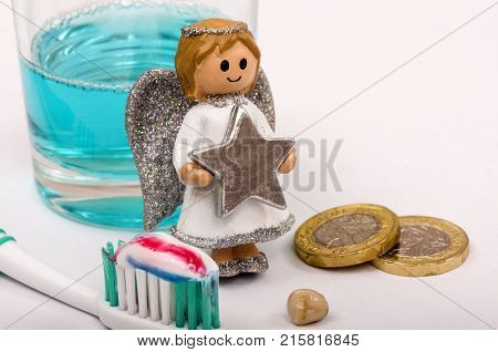 The tooth Fairy next to a tooth, toothbrush and mouth wash. The tooth fairy leaves a reward in exchange for a tooth that has fallen out.