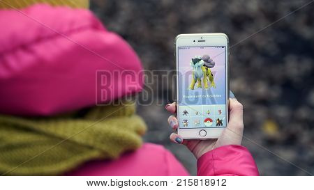 Samara, Russia - November 28, 2017: woman playing pokemon go on his iphone. pokemon go multiplayer game with elements of augmented reality.