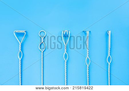 Speech therapy tools on a blue background. Logopedic metal probes. The use of special tools for speech correction