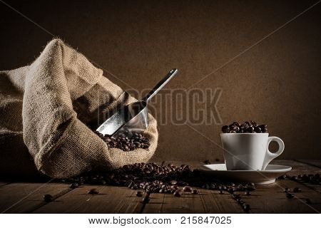 Background of cup of coffee beans with jute bag and bailer