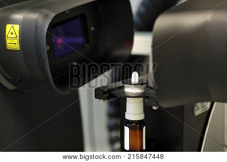 The Worker Measures The Size Of The Particles And Drops Of The Spray. Pharmaceutical Industry And La