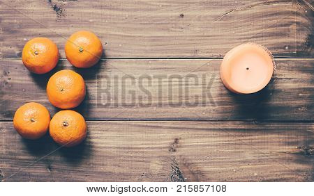 Mandarins and candle on the wood table background