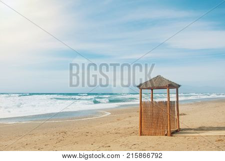 Wild Abandoned Unexplored Beach With A Lonely Wooden Wicker Construction, Bright Blue Turquoise Sea