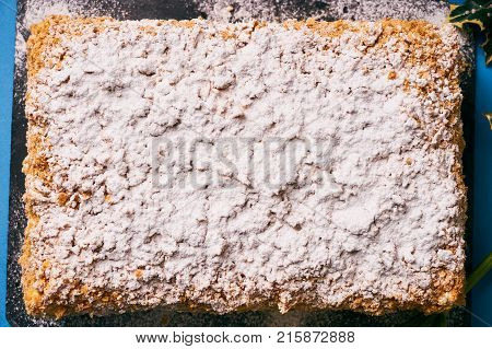 Cake Napoleon with sour cream. Layered puff pastry napoleon cake with powdered sugar and butterscotch frosting on sackcloth decoration background. Sweet dessert food