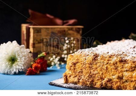 Delicious Napoleon cake with with sour cream. Layered puff pastry napoleon cake with powdered sugar and butterscotch frosting on sackcloth decoration background. Sweet dessert food