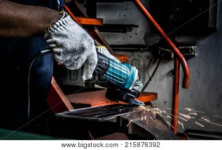 Metal grinding on the iron plate with flash of sparks close up backgrond