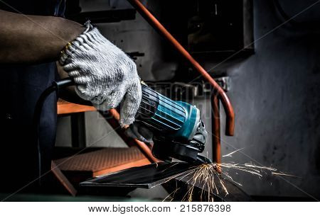 Metal grinding on the iron plate with flash of sparks close up background steel