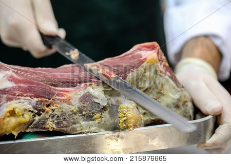 Cutting slices of cured iberian ham .