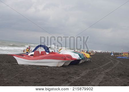 photo pedal catamarans of different flowers on the bank sea. Travel or sea vacations concept