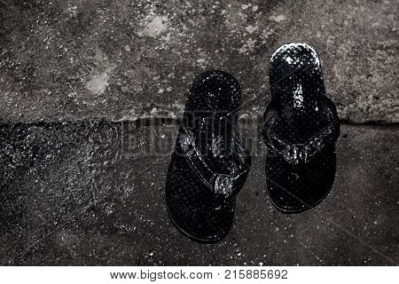 Sandal in rainyday puddles and splashing water Summer is over.Back and white tone.