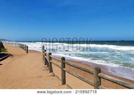 Wooden Pole Barrier On Beachfront Against Coastal  Landscape