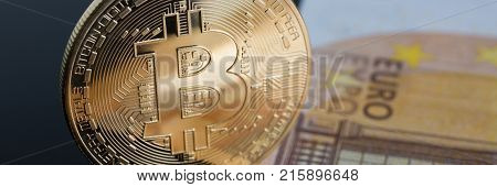 The coin of crypto currency bitcoin against background euro banknote subject gold exchange pyramid for money in connection with the growth or fall exchange rate closeup.