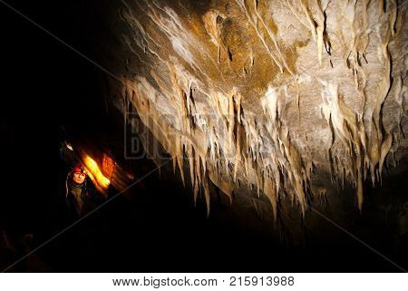 Spelunker wondering in a beautiful cave with stalactites