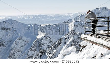 Beautiful snowy peaks in winter. Man looking from peak Lomnicky stit in High Tatras mountains Slovakia