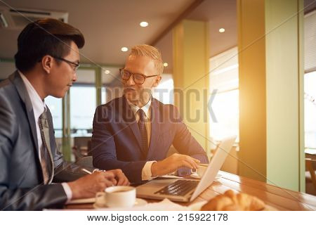 Cheerful business people having meeeting in sunny cafe