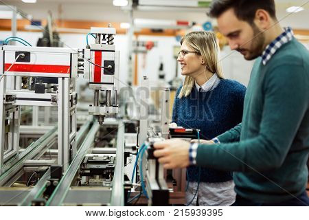 Young attractive students of mechatronics working on project together