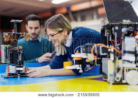 Young attractive students of mechatronics working on project together