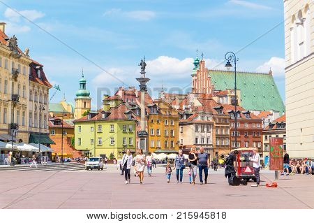 WARSAW POLAND - MAY 23 2017: People walking in famous area of Warsaw with beautiful old buildings in the background. Warsaw is becoming more and more popular among tourists every year.