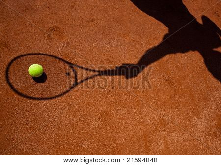 sombra de um jogador de tênis em ação em um campo de ténis