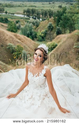 Portrait Of A Young Beautiful Smiling Bride On A Background Of A Gorgeous View Of The River And Fiel