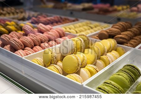 Different types of macaroons on blured background in candy shop