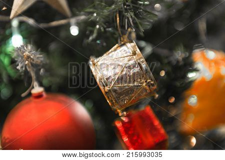 Christmas white silver drum hanging on a beautiful Chrismas tree surrounded by red shinning ball