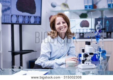 Smiling Senior Doctor Woman Working With Microscope At Laborator