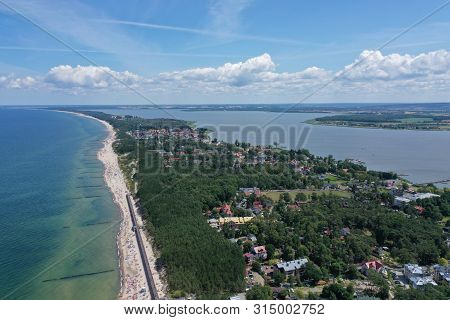 Drone Aerial Perspective View On Touristic City Located On Narrow Spit Between Sea And Lake With Sun