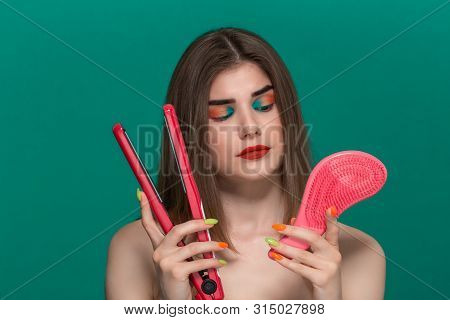 Portrait Of Beautiful Young Woman With Bright Color Make-up Doing Hair Style Herself With A Purple S