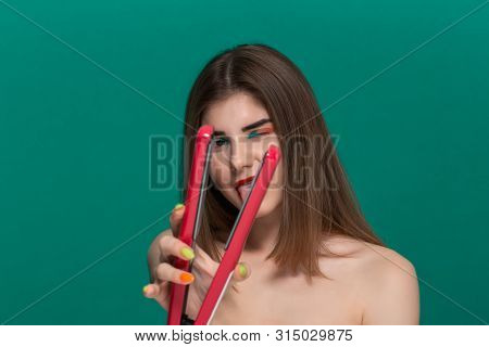Portrait Of Beautiful Young Woman With Bright Color Make-up Doing Hair Style Herself With A Purple S