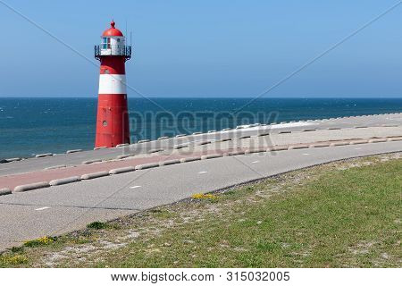 Lighthouse At Dike Near Westkapelle In The Netherlands