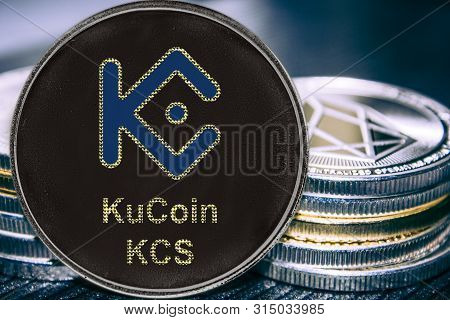 Coin Cryptocurrency Kcs Kucoin On The Background Of A Stack Of Coins.