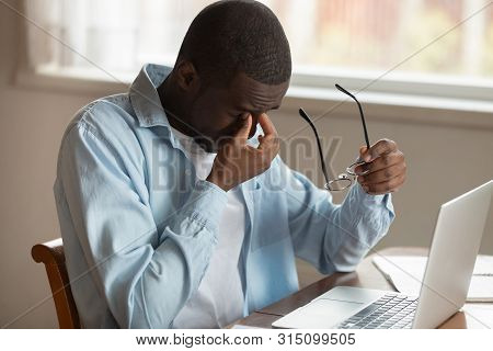 African Guy Sit Near Laptop Taking Off Glasses Reduce Eyestrain
