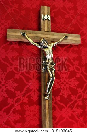 Close-up Of Wood Crucifix On Red Material - Concept That Jesus Shed His Holy Blood To Save Us And Ho