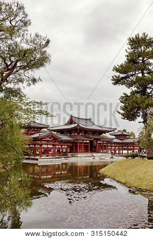 Kyoto, Japan - April 17th, 2018: Byodoin Temple Reflecting Against A Pond In The Town Of Uji, Kyoto,