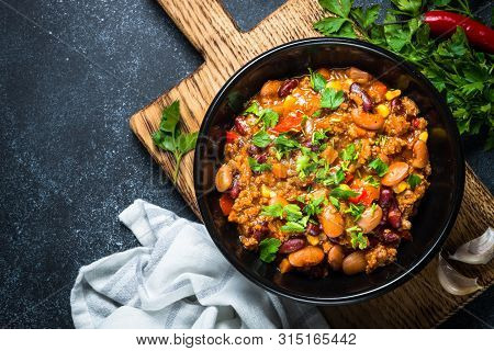 Chili Con Carne From Meat, Beans And Vegetables On Black Stone Table. Traditional Mexican Food. Top 