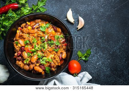 Chili Con Carne From Meat, Beans And Vegetables On Black Stone Table. Traditional Mexican Food. Top 