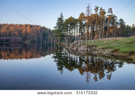 Stunning Landscape Image Of Tarn Hows In Lake District During Beautiful Autumn Fall Evening Sunset W