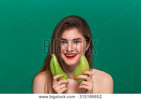 Closeup Portrait Of Beautiful Young Woman With Bright Color Make-up Holding Green Pepper Standing Is