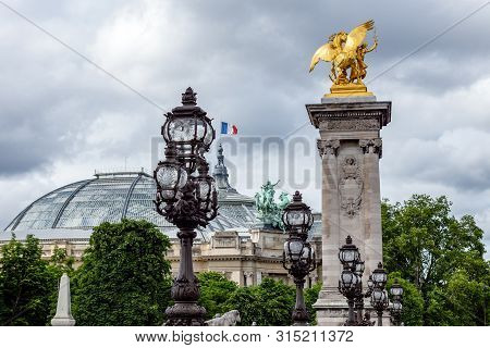 Art Nouveau Lamps On Pont Alexandre Iii Bridge With Grand Palais In Background - Paris France