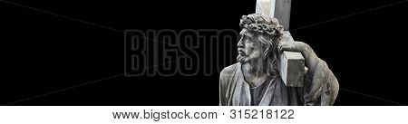 The Crucifixion Of Jesus Christ  In Profile. Antique Statue Isolated On Black Background.