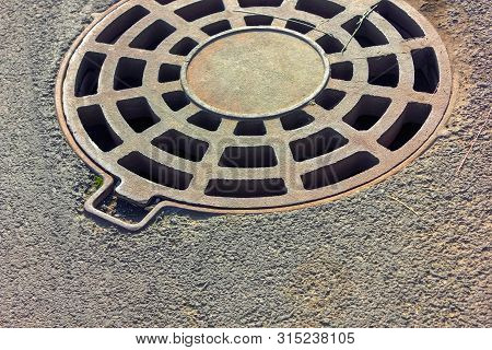 Cast-iron Manhole Of The Storm Sewer System In The Park.