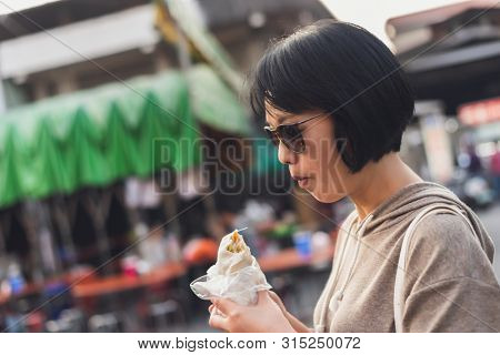 woman eat traditional Taiwanese snack of spring roll