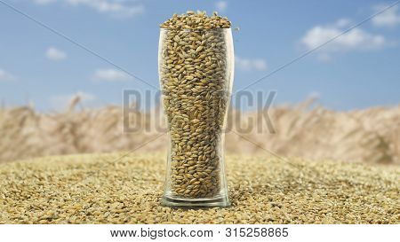 A Full Glass Of Malt-filled Beer Glass Stands On A Malt Against A Wheat Field And Blue Sky.