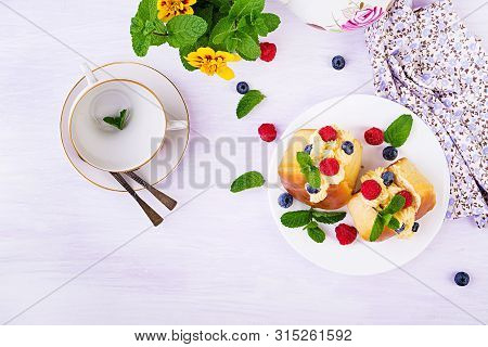 Rum Baba Decorated With Whipped Cream And Fresh Raspberry, Blueberry. Savarin With Rum, Cream And Be