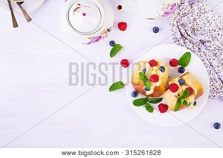 Rum Baba Decorated With Whipped Cream And Fresh Raspberry, Blueberry. Savarin With Rum, Cream And Be