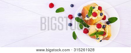 Rum Baba Decorated With Whipped Cream And Fresh Raspberry, Blueberry. Savarin With Rum, Cream And Be