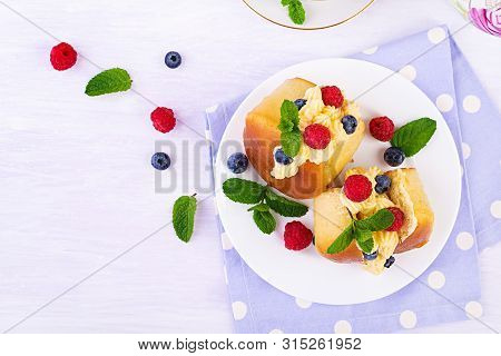 Rum Baba Decorated With Whipped Cream And Fresh Raspberry, Blueberry. Savarin With Rum, Cream And Be